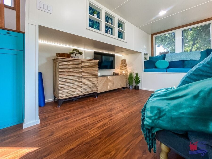 Entertainment center built neatly under the landing inside the Indigo River Tiny Homes Entertainer model.