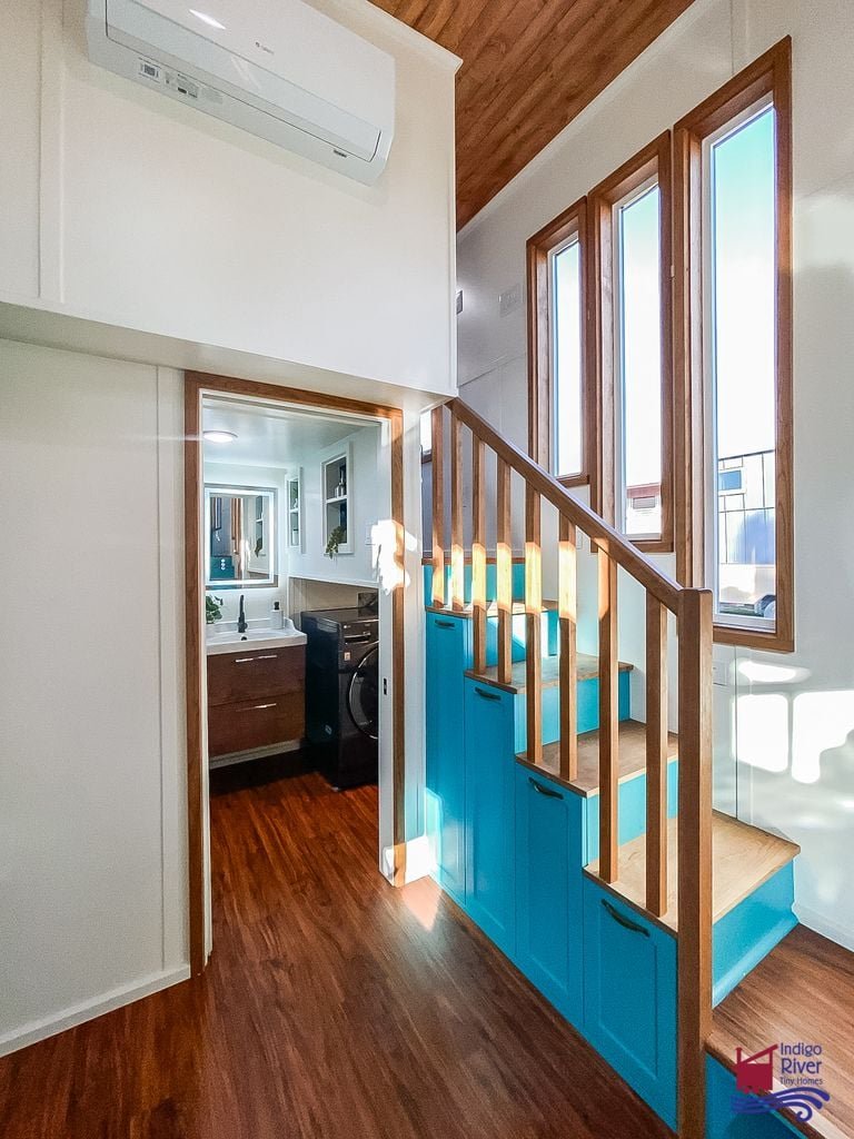 Sturdy storage staircase leading to the main standing-height bedroom in the Tree House tiny house.