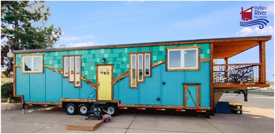 Overhead view of the Indigo River Tiny Homes Entertainer model showing turquoise cabinets, kitchen island, and living area in a 3-bedroom tiny house on wheels.