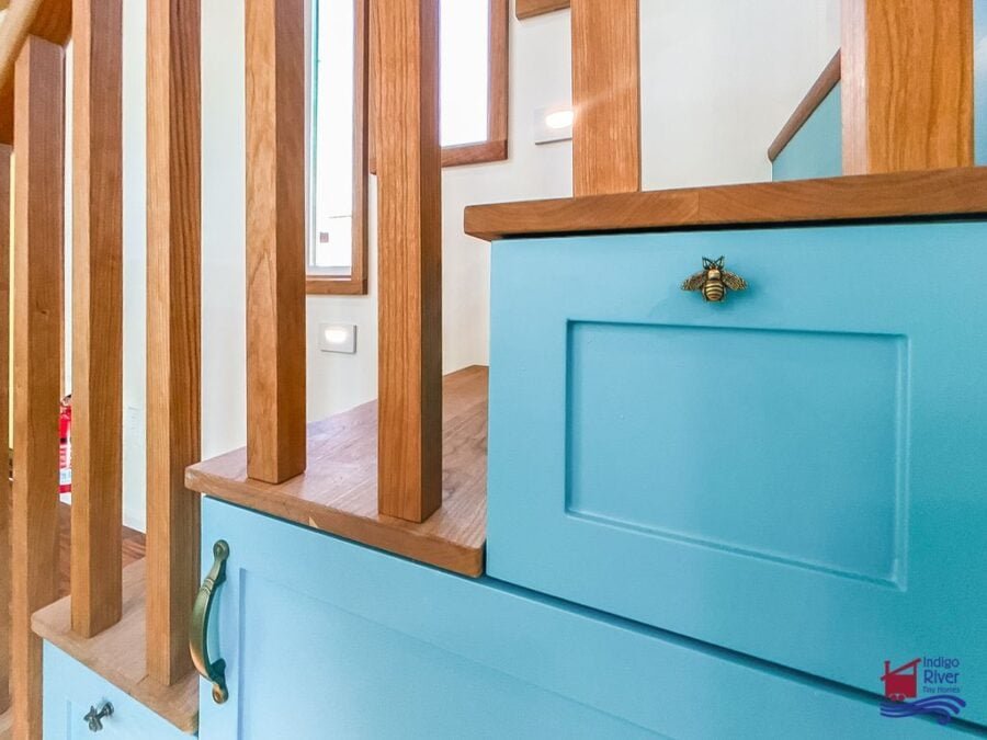 Bee-shaped cabinet knobs adding charming detail to the tiny house kitchen design.