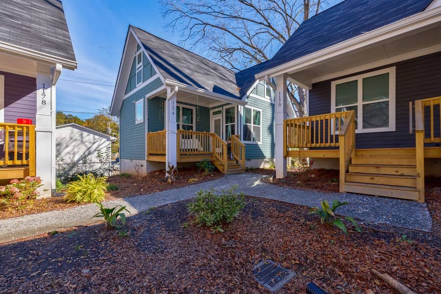 Eight colorful micro cottages surrounding shared green space at Cottages on Vaughn in Clarkston, Georgia.