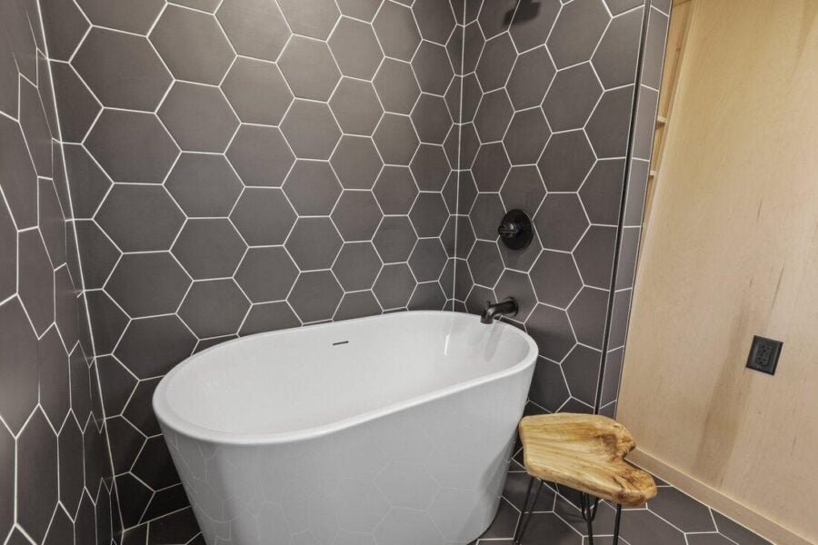 Spa-style bathroom with bold black hexagon tile in the Sangja tiny house