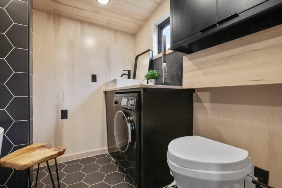 Composting toilet positioned beside the washer and dryer unit inside the Sangja tiny house.