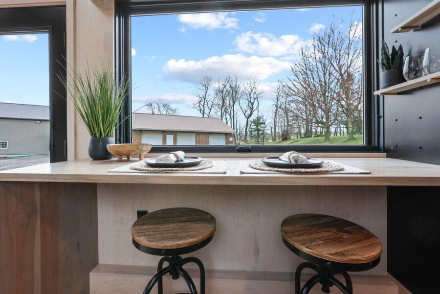 Dining area in the Sangja tiny house showcasing oversized windows with scenic views.