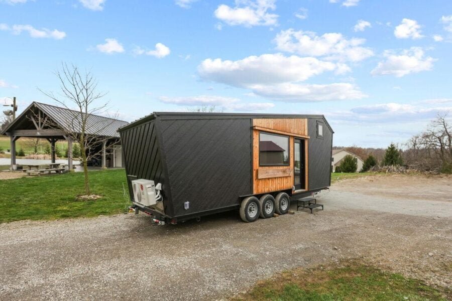 Exterior front view of the 28ft Sangja tiny house by Modern Tiny Living with black siding and modern design.